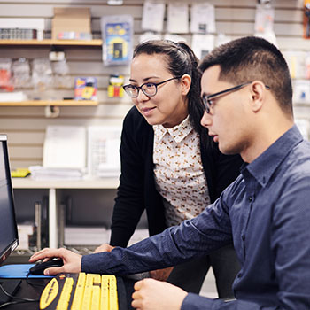 Optometrist observing patient accesing web page on a desktop computer in a lab environment